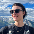 Person wearing sunglasses with mountains in the background