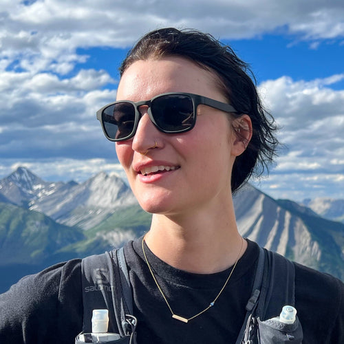 Person wearing sunglasses with mountains in the background